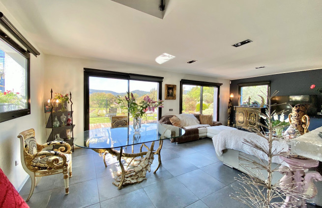 Lichte woonkamer met erker en uitzicht op de tuin/het zwembad