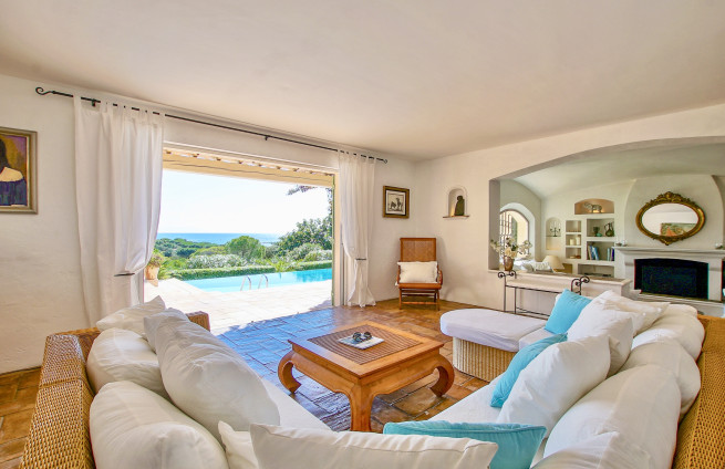 Woonkamer met open haard, die uitkomt op een terras met uitzicht op zee in Sainte-Maxime.