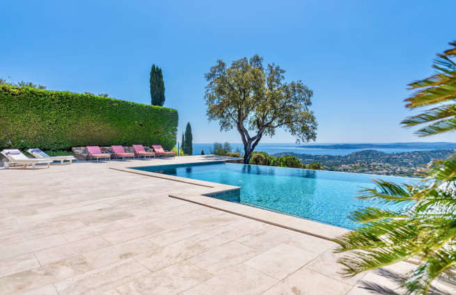heated infinity pool with Mediterranean garden