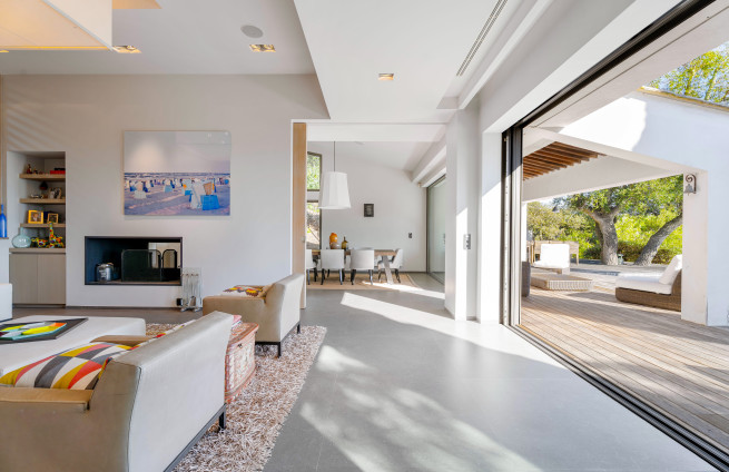 Luxe woonkamer met open haard, terras en uitzicht op zee.