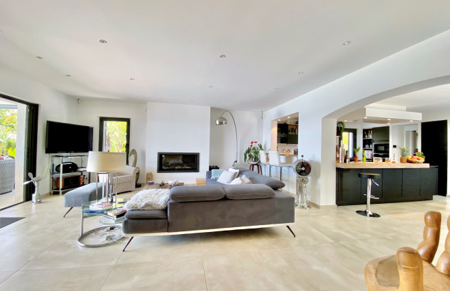 Woonkamer met open haard en inzethaard in een te koop staande villa in Sainte-Maxime.