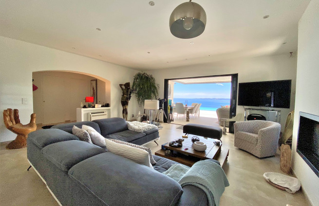 Woonkamer met open haard, die uitkomt op een terras met uitzicht op zee bij Sainte-Maxime.