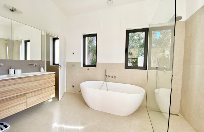 Luxe master suite met ligbad, douche en op maat gemaakte kleedkamer.